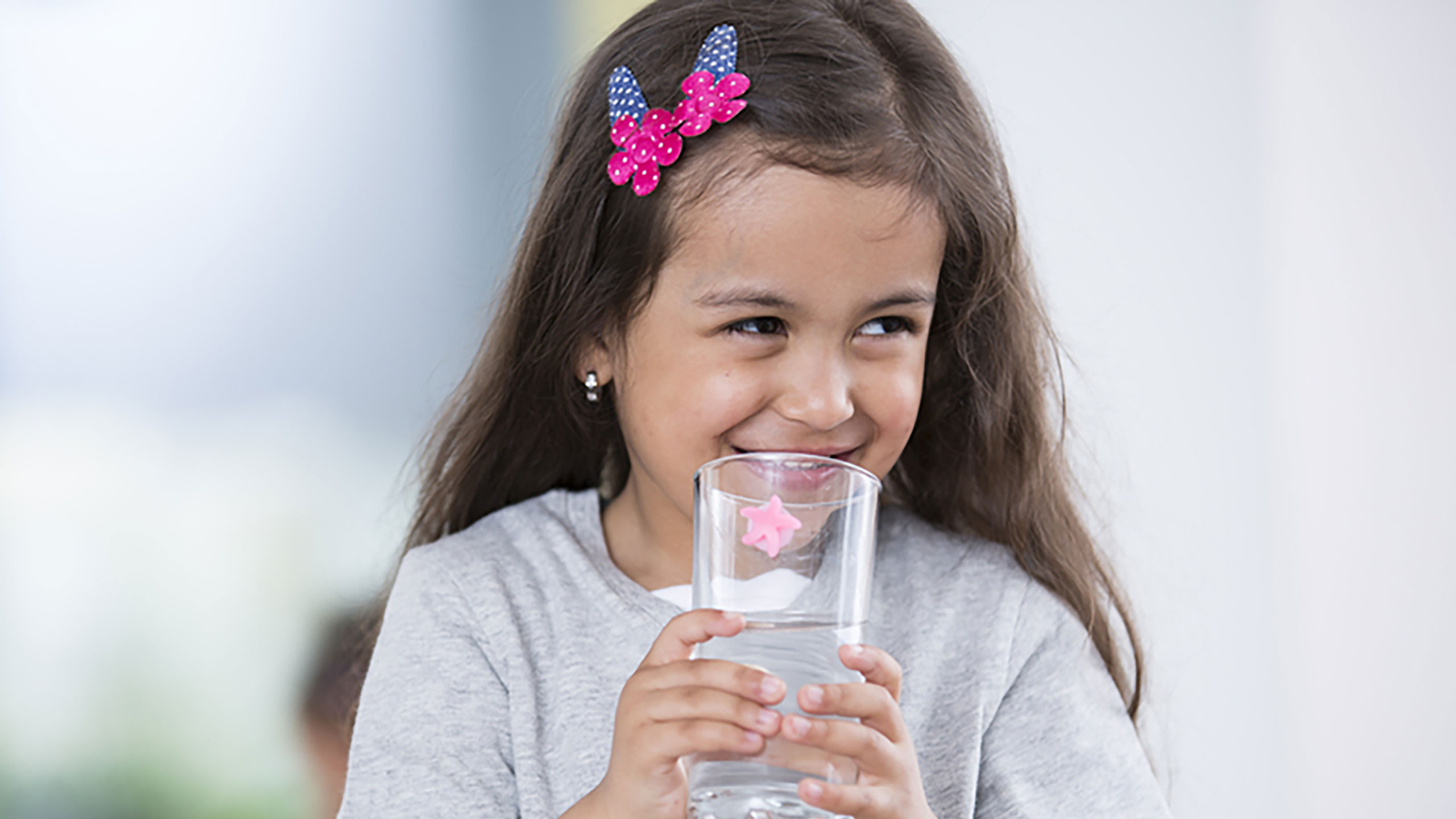 Child hydrating with glass of water